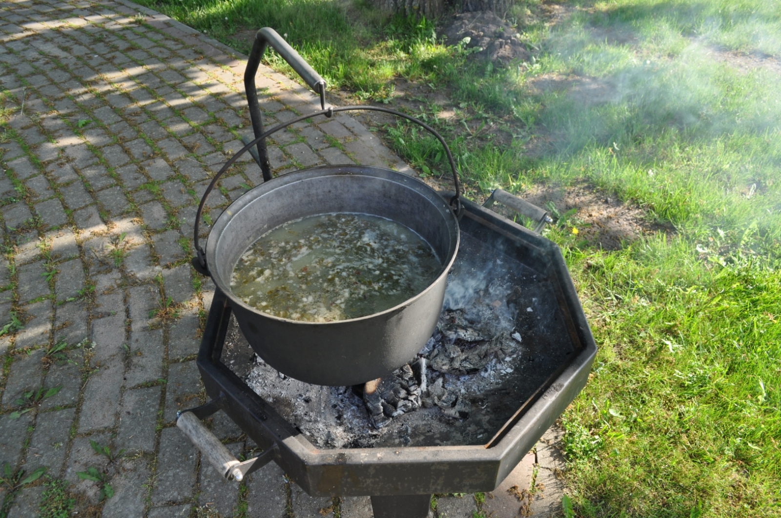 Zupas vārīšana katlā uz ugunskura muzeja pagalmā