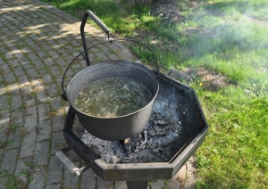 Zupas vārīšana katlā uz ugunskura muzeja pagalmā