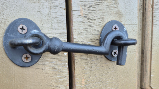 Tumši pelēks krampis aizkrampējis brūni pelēkas durvis