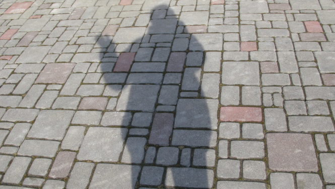 Cilvēka ēna uz bruģa