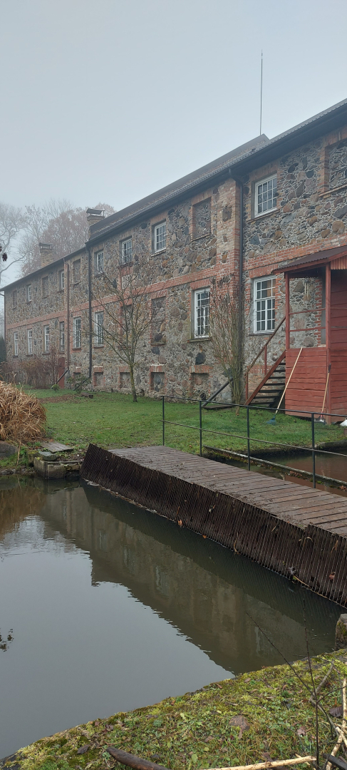 Tilts pāri mazai upītei, ar skatu uz dzirnavu mājas pusi