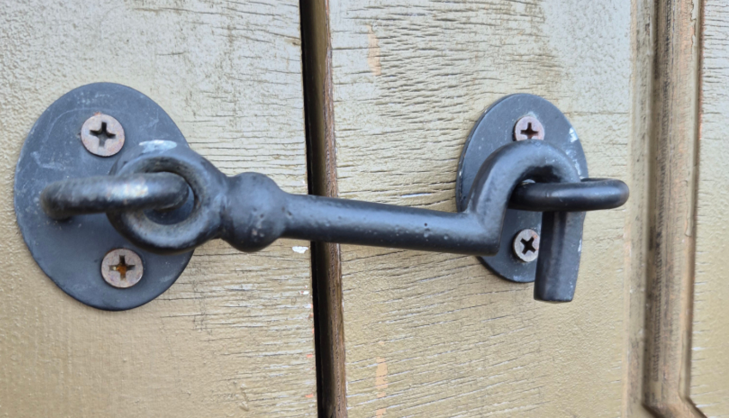 Tumši pelēks krampis aizkrampējis brūni pelēkas durvis