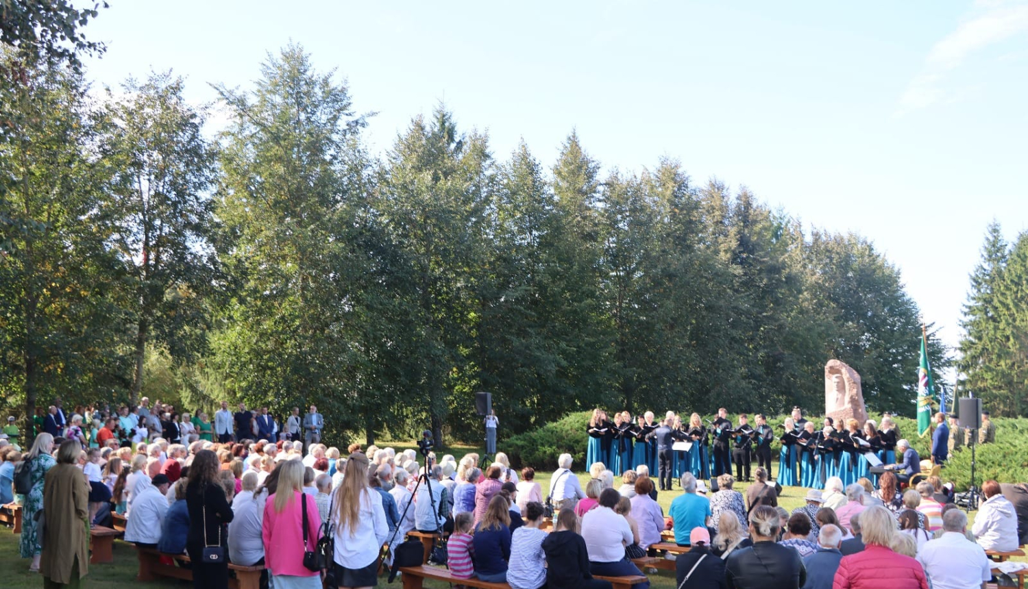 Atceres pasākuma dalībnieki klausās dziedātāju koncertu pie K.Ulmaņa pieminekļa